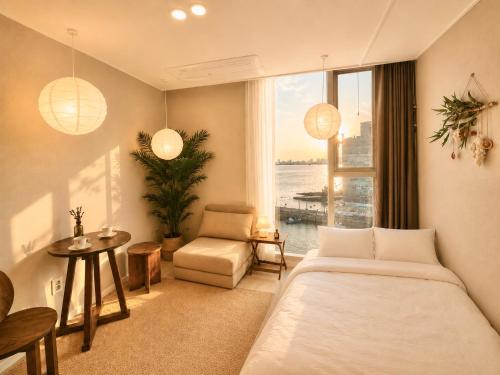 a bedroom with a bed and a table and a window at Mood-Ocean 영종도 오션파크나인호텔 in Chagyak-to