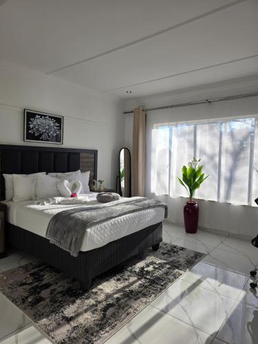 a bedroom with a large bed and a large window at Flourish Haven Escape in Germiston