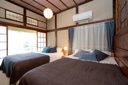 a bedroom with two beds and a window at 横須賀-1軒家2棟 in Yokosuka