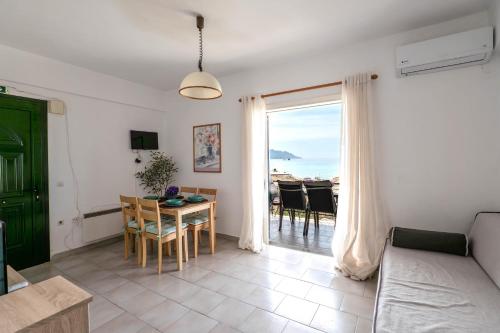 a living room with a table and a view of the ocean at Corfu Dream Holidays Villas Standarts in Glyfada