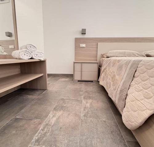 a bedroom with a bed and a tiled floor at Orchidea Apartments in Sorso