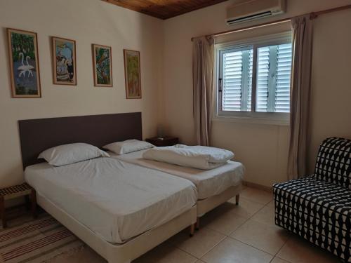 a bedroom with a bed and a window and a chair at Greenfield House in Psevdhas