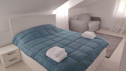 a bedroom with a blue bed and a chair at Eden House Șelari in Şelari