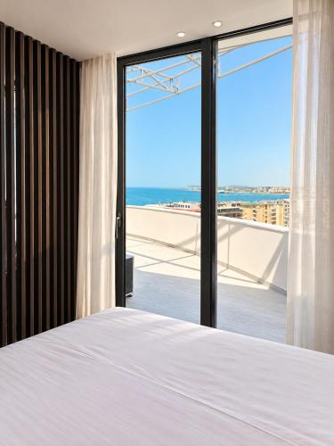 a bedroom with a bed and a view of the ocean at Emera Apartments in Vlorë