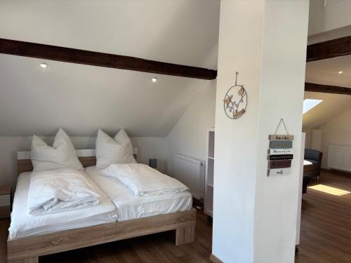 a bed with white sheets and pillows in a room at Vilseck Stay in Vilseck