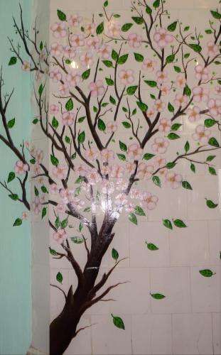 a tree painted on a wall with pink flowers at Vishnya Hostel in Dnipro