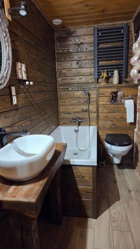 a bathroom with a sink and a tub and a toilet at Zacisze 13 in Leśna