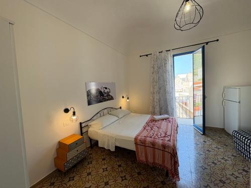 a bedroom with a bed and a sliding glass door at Struttura Le Gemme in Marettimo