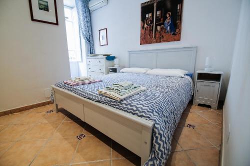 a bedroom with a bed with a blue and white comforter at Fausto's House in Siracusa