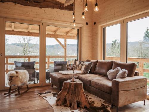 ein Wohnzimmer mit Sofa und Tisch in der Unterkunft Romantikchalet Vogelnest mit Whirlpool, Kamin, Balkon & Terrasse in Vorra