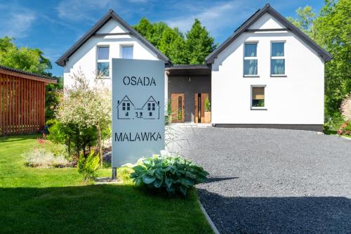 a house with a sign in front of a driveway at Osada Malawka pod Śnieżką - wypoczynek w saunie lub jacuzzi z widokiem na góry in Karpacz