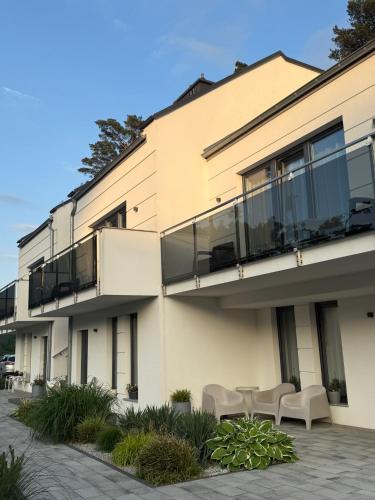 an apartment building with balconies and a patio at Apartamenty Marco Polo in Dziwnówek