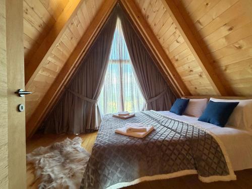 a bedroom with a bed with a large window at Durmitor Den in Žabljak