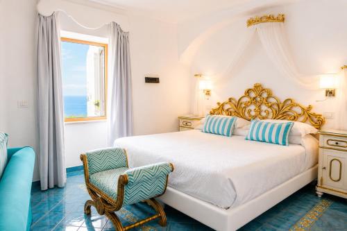 a white bedroom with a bed and a window at Hotel Conca d'Oro in Positano