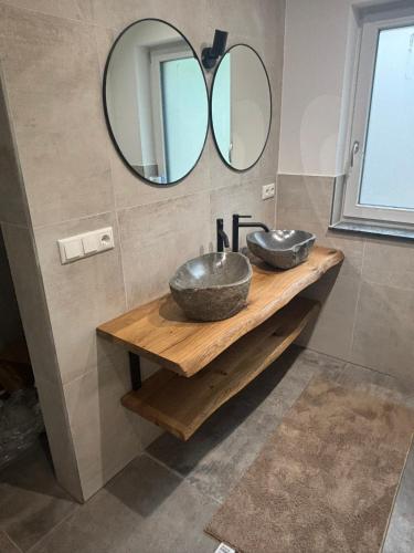 a bathroom with two vessel sinks and a mirror at SchiScho's Lodge in Sankt Kathrein am Offenegg