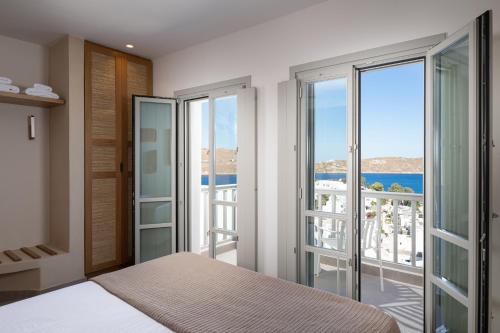 a bedroom with a bed and views of the ocean at Gea Perla Serifos in Livadi