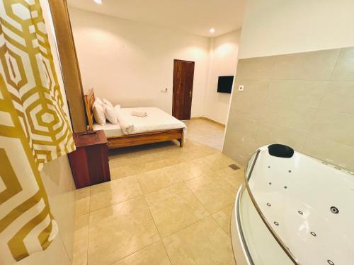 un bagno con vasca, letto e specchio di Panda Hostel a Zanzibar City