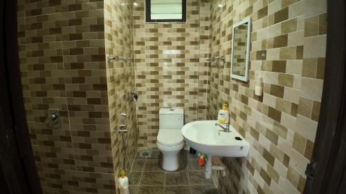 a bathroom with a toilet and a sink at Samwise Escapade Hillside Guesthouse - Master Room in Kampong Perlis