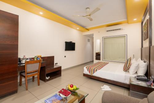 a hotel room with a bed and a desk and a computer at Regenta Central North Goa, Arpora in Arpora