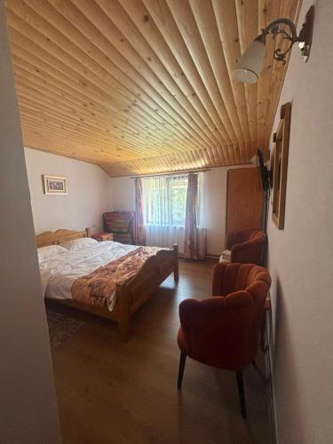 a bedroom with a bed and a wooden ceiling at Pensiunea Mery in Albac