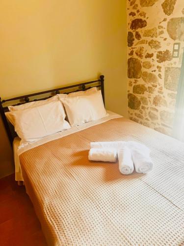 a bed with two folded towels on top of it at Kyma in Gerolimenas