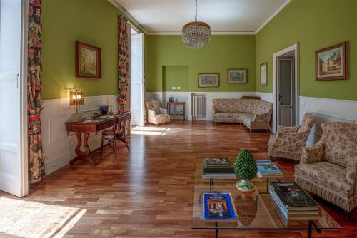 a living room with green walls and a wooden floor at I Sogni della Memoria in Ragusa