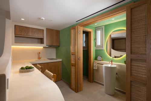 a kitchen with green walls and a white counter top at Gea Perla Serifos in Livadi