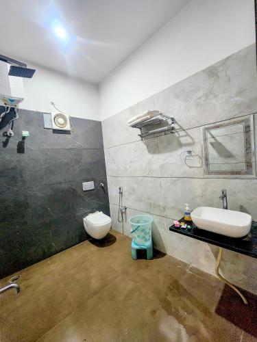 a bathroom with a sink and a toilet at Hotel Shree Karni Palace in Deshnoke