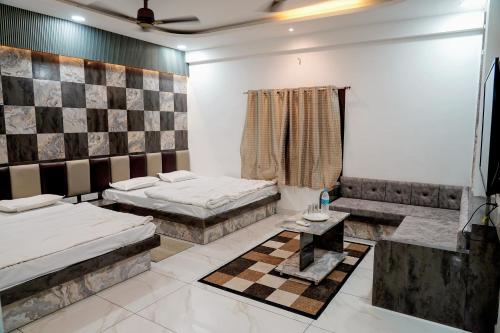 a room with two beds and a table in it at Hotel Shree Karni Palace in Deshnoke