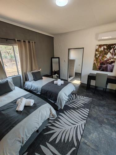 a hotel room with two beds with towels on them at Masango Lodge in Hoedspruit