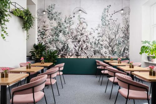 a wall mural in a restaurant with tables and chairs at Hotel Botanica by goodnite cz in Brno
