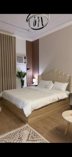 a bedroom with a large bed and a chandelier at Ksa3 in Hail