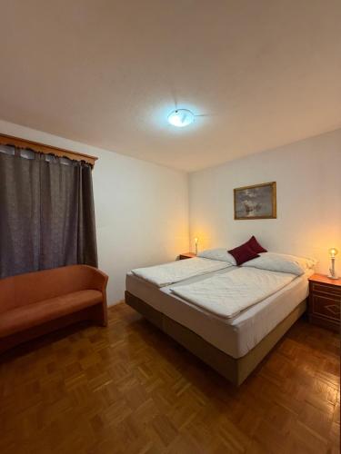 a bedroom with a bed and two lamps and a window at Hiša Mila in Bovec