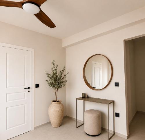 a room with a ceiling fan and a table and a mirror at athanasian side sea view home in Polychrono