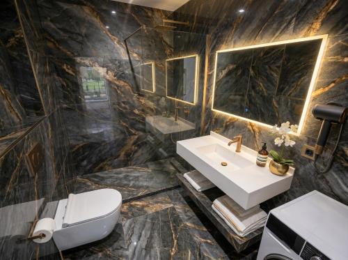 a bathroom with a sink and a toilet at Alfred Promenade Apartments in Sarandë