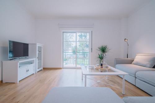 a living room with a couch and a table at Casa do Jardim in Olhão