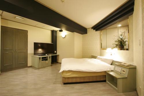 - une chambre avec un lit et une télévision à écran plat dans l'établissement Hotel NOA (Adult Only), à Anjomachi