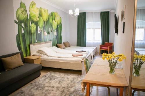 a room with a bed and a couch and a table at V8-Kelemen Panzió in Makó