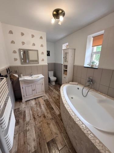 a bathroom with a tub and a sink and a toilet at Ubytovanie Lišov 3 - Vidiecky dom in Lišov
