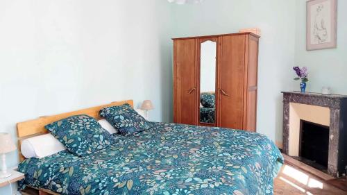 a bedroom with a bed and a cabinet and a fireplace at Charming house in Montbron
