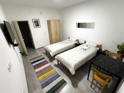 a room with two beds and a table in it at Gorica in Negotin
