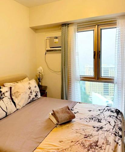 a bedroom with a bed with a window at New OneHeart Avida Riala T5 Condo in Cebu City