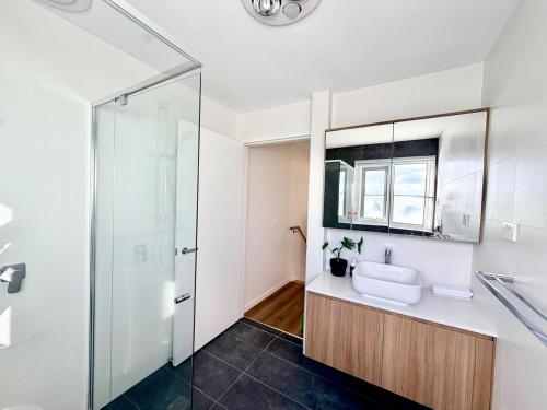 a bathroom with a sink and a glass shower at C02-Diamond Loft 2BR apart, elevated living style in Ginninderra
