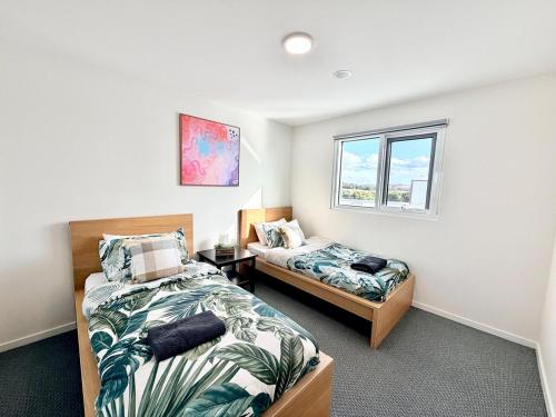 a bedroom with two beds and a window at C02-Diamond Loft 2BR apart, elevated living style in Ginninderra