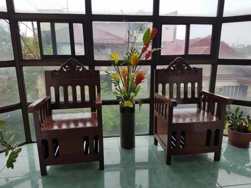 two chairs with a vase of flowers in a room at N&J Lopez Lodging House in Manila