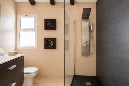 a bathroom with a shower with a toilet and a window at MiVida in San Bartolomé