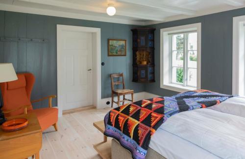 a bedroom with a bed and a desk and a chair at Østigård 1810 Prestegårdshuset in Åndalsnes