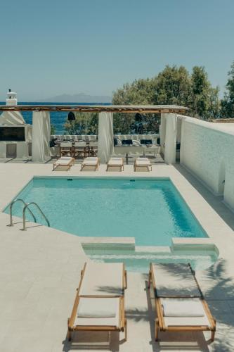 a swimming pool with two lounge chairs and a swimming pool at Damma Villa in Kamari