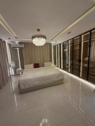 a bedroom with a bed and a chandelier at Xclusive Luxury Apt in Mopo Onijebu
