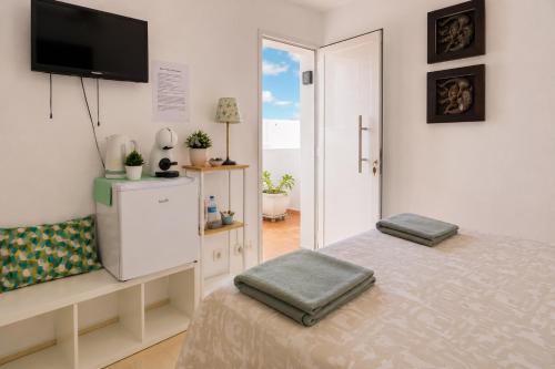 a bedroom with a bed and a tv on the wall at MiVida in San Bartolomé
